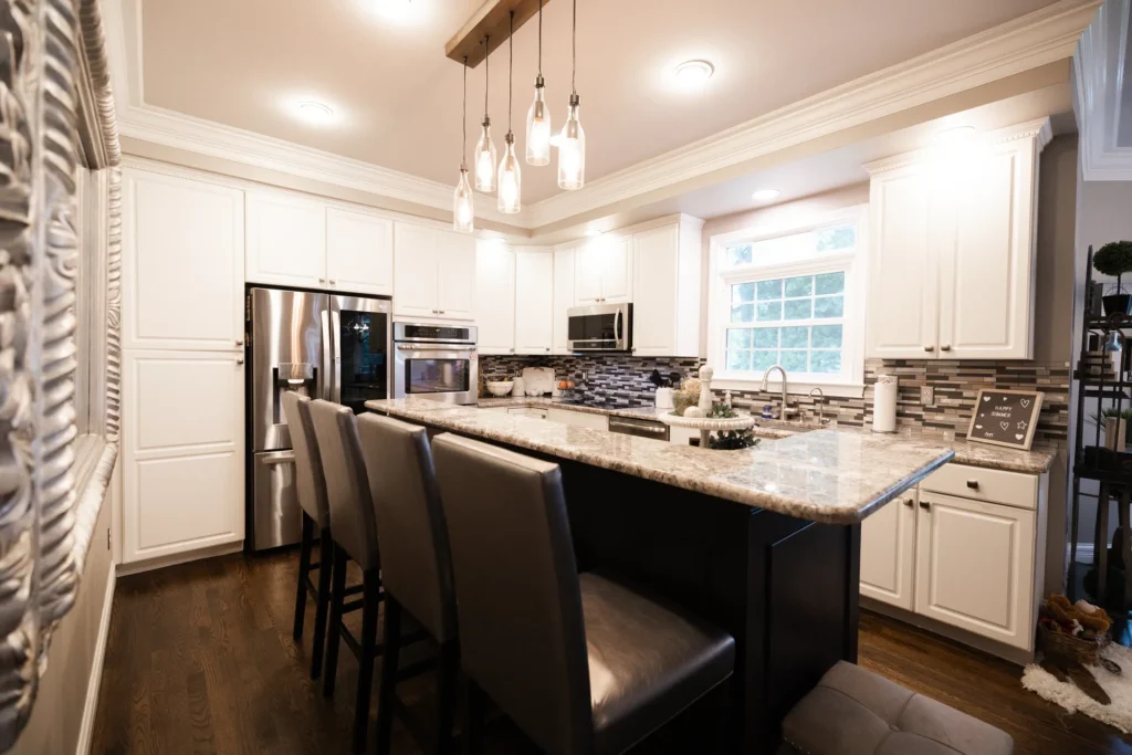 Kitchen Remodeling Kitchen remodel by American Home with white cabinets, granite counters and a dark island